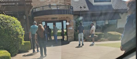 A picture of people waiting outside. For a restaurant to open